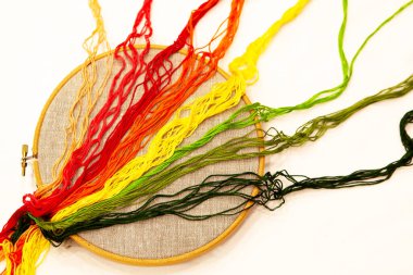 Embroidery hoop with natural linen fabric, with embroidery threads.