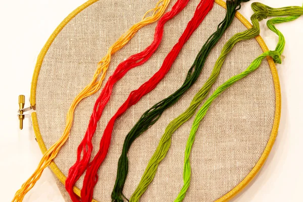 刺繍糸でフープの上に 自然なリネン生地で刺繍フープ 異なる色 トップビューのためのスレッドの選択は 白に隔離 — ストック写真