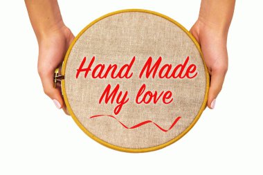 Kadınların elinde doğal keten kumaşlı nakış halkası, izole. Yazılı şablon - el yapımı aşk, üst görünüm.