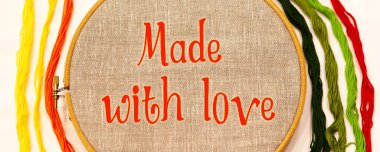 Doğal keten kumaşlı nakış halkası, her iki tarafın yanında beyaz arka planda farklı renklerde nakış iplikleri var, üst görünümde..