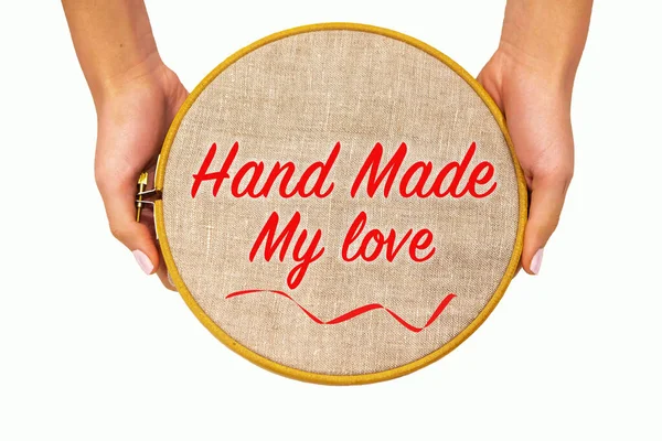 Kadınların elinde doğal keten kumaşlı nakış halkası, izole. Yazılı şablon - el yapımı aşk, üst görünüm.