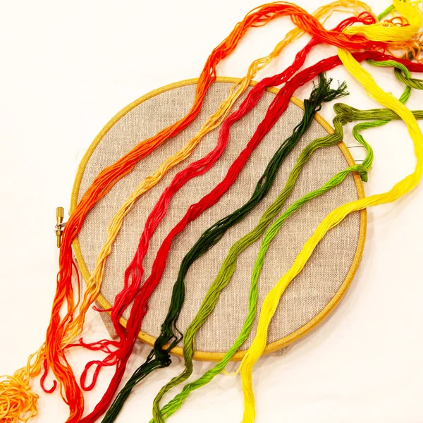 刺繍糸でフープの上に 自然なリネン生地で刺繍フープ 異なる色 トップビューのためのスレッドの選択は 白に隔離 — ストック写真