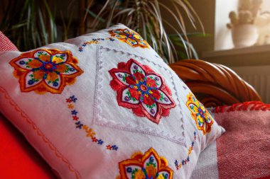 Beyaz keten yastığa renkli mandala nakış tasarımı.