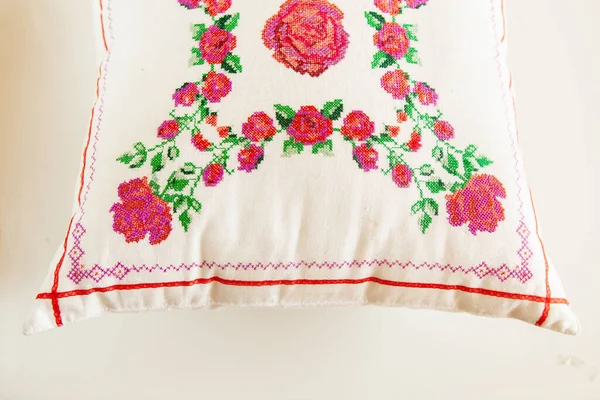 Cross-stitch embroidery in the form of roses on a white linen pillow. — Stock Photo, Image