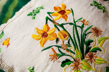 Beyaz keten yastığa renkli nakış tasarımı.