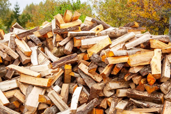 Stock of firewood for heating the house. The trees were cut down and split into firewood to be used as heating fuel in fireplaces and stoves, firewood background.