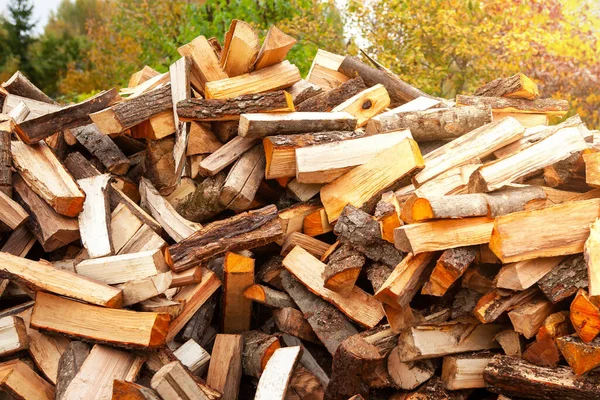 Stock of firewood for heating the house. The trees were cut down and split into firewood to be used as heating fuel in fireplaces and stoves, firewood background.