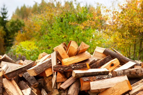 Hromada štípaného dřeva na topení domu, na otevřeném prostranství. — Stock fotografie