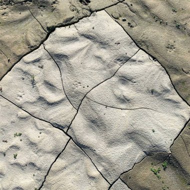Çatlak yeryüzü arka planı. Toprak yüzeyinde çatlaklar var. Çamur çatlakları.