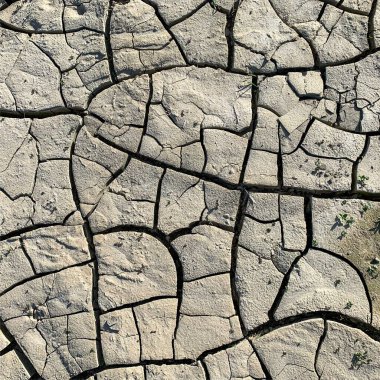 Çatlak yeryüzü arka planı. Toprak yüzeyinde çatlaklar var. Çamur çatlakları.