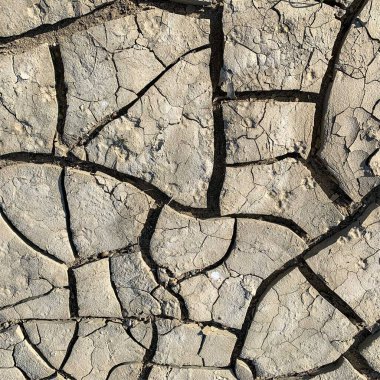 Çatlak yeryüzü arka planı. Toprak yüzeyinde çatlaklar var. Çamur çatlakları.