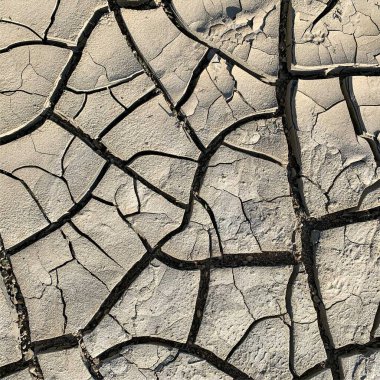 Çatlak yeryüzü arka planı. Toprak yüzeyinde çatlaklar var. Çamur çatlakları.