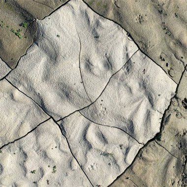 Çatlak yeryüzü arka planı. Toprak yüzeyinde çatlaklar var. Çamur çatlakları.