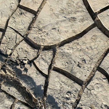 Çatlak yeryüzü arka planı. Toprak yüzeyinde çatlaklar var. Çamur çatlakları.