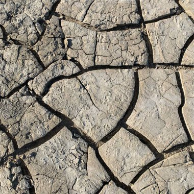 Çatlak yeryüzü arka planı. Toprak yüzeyinde çatlaklar var. Çamur çatlakları.