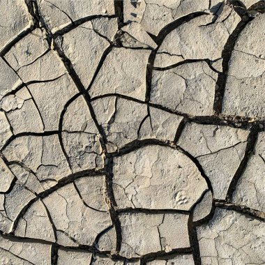 Çatlak yeryüzü arka planı. Toprak yüzeyinde çatlaklar var. Çamur çatlakları.