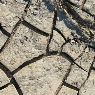 Çatlak yeryüzü arka planı. Toprak yüzeyinde çatlaklar var. Çamur çatlakları.
