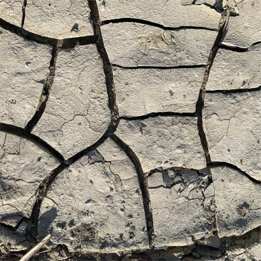 Çatlak yeryüzü arka planı. Toprak yüzeyinde çatlaklar var. Çamur çatlakları.