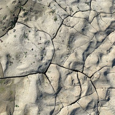 Çatlak yeryüzü arka planı. Toprak yüzeyinde çatlaklar var. Çamur çatlakları.