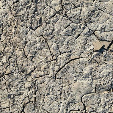Çatlak yeryüzü arka planı. Toprak yüzeyinde çatlaklar var. Çamur çatlakları.
