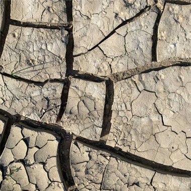 Çatlak yeryüzü arka planı. Toprak yüzeyinde çatlaklar var. Çamur çatlakları.