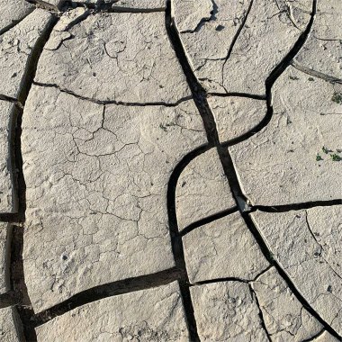 Çatlak yeryüzü arka planı. Toprak yüzeyinde çatlaklar var. Çamur çatlakları.