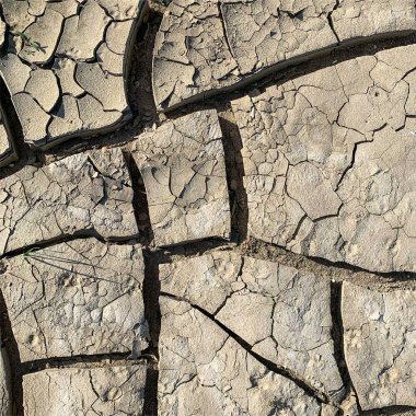 Çatlak yeryüzü arka planı. Toprak yüzeyinde çatlaklar var. Çamur çatlakları.