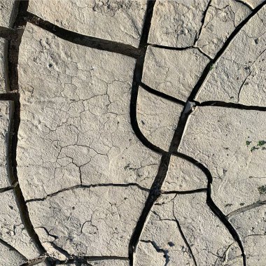 Çatlak yeryüzü arka planı. Toprak yüzeyinde çatlaklar var. Çamur çatlakları.