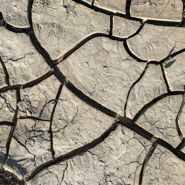 Çatlak yeryüzü arka planı. Toprak yüzeyinde çatlaklar var. Çamur çatlakları.