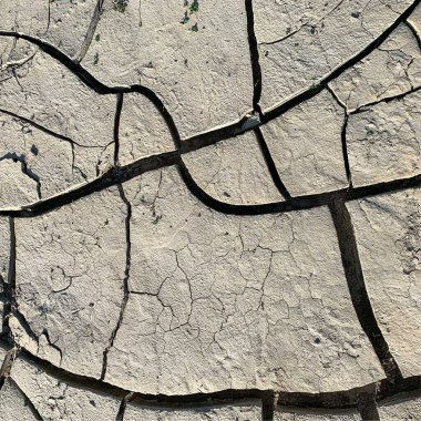 Çatlak yeryüzü arka planı. Toprak yüzeyinde çatlaklar var. Çamur çatlakları.