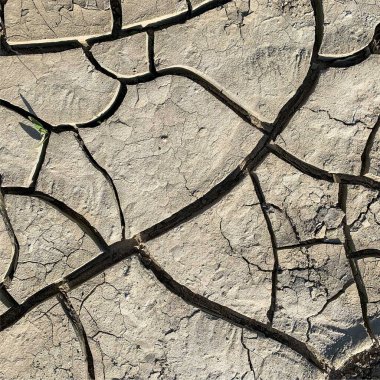 Çatlak yeryüzü arka planı. Toprak yüzeyinde çatlaklar var. Çamur çatlakları.