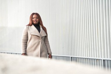 Zeki giyimli iş kadını yürüyor. Takım elbiseli Afrikalı Amerikalı kadın portresi.