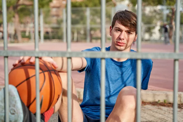 Joven Atleta Con Una Pelota Baloncesto Mano Sentado Cancha Baloncesto — Foto de Stock