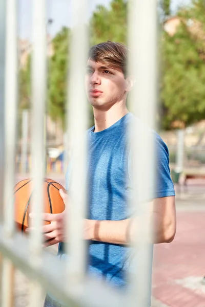 Joven Deportista Con Una Pelota Baloncesto Mano Apoyada Contra Una — Foto de Stock