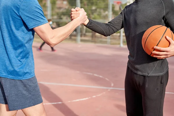 Tanımlanamayan arkadaşlar kortta birbirlerine beşlik çakıyorlar. Spor ve arkadaşlık kavramı