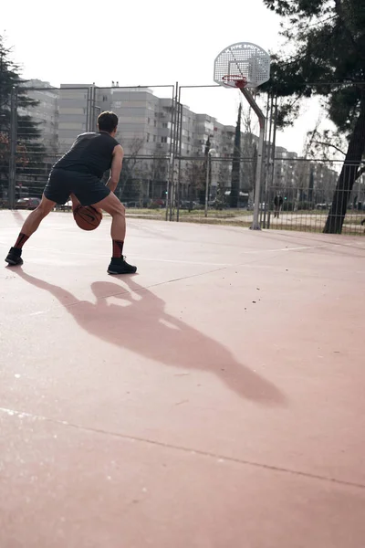 Joven Jugando Baloncesto Aire Libre Calle Con Largas Sombras —  Fotos de Stock