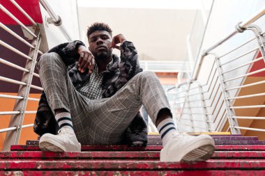 Genç ve çekici bir öğrenci şehrin merdivenlerinde oturuyor..