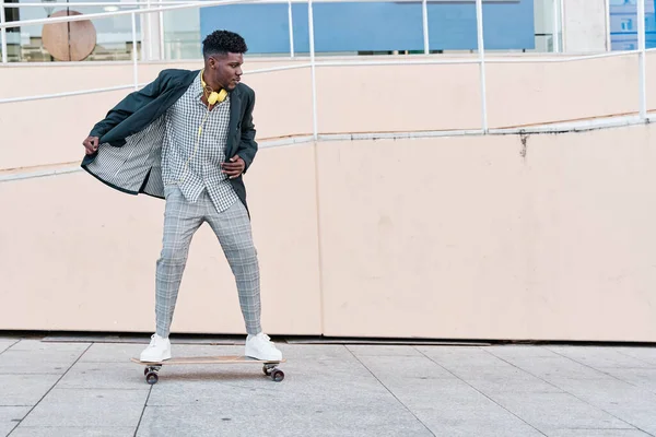 Genç işadamı takım elbise içinde kaykaya biniyor.