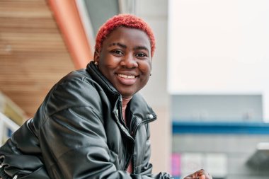 Gülümseyen ve kameraya bakan Afro-Amerikan bir kadının portresi.