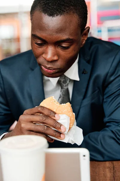 African American Businessman Suit Sitting Restaurant Eating Burger Using Tablet — Stock Photo, Image