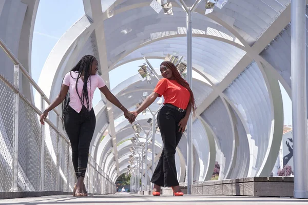 İki bin yıllık örgülü genç Afro-Amerikalı çift el ele yürüyorlar..