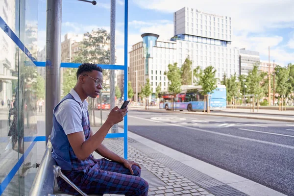 Hombre Esperando Parada Autobús Mientras Mira Teléfono Inteligente — Foto de Stock