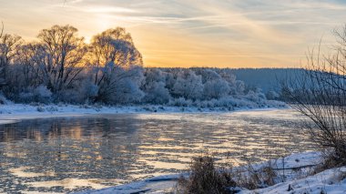 Winter sunset view of the San river and snow-covered trees