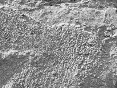 Dekoratif alçı tabakasıyla kaplı eski bir duvar. Siyah beyaz tek renkli fotoğraf..