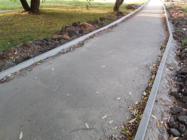 Yol onarımı ve inşaatı. Eski kaldırımın kenarına beton kaldırım taşı (asfalt) monte edilecek..