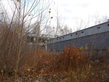 Terk edilmiş bir anaokulunun bölgesi. Binada kırık pencereler var, pencereler demir çarşaflarla kaplı..