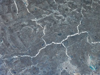 Yerdeki derin ve pürüzlü çatlaklar. Renk tersi efektli fotoğraf.