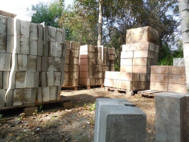Beton bloklar, taklit taş ve köpük yalıtımına (yalıtım) bakıyor. İnşaat alanının yakınındaki inşaat malzemeleri bir kır evi inşaatı için hazırlanıyor..