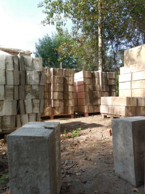 Beton bloklar, taklit taş ve köpük yalıtımına (yalıtım) bakıyor. İnşaat alanının yakınındaki inşaat malzemeleri bir kır evi inşaatı için hazırlanıyor..