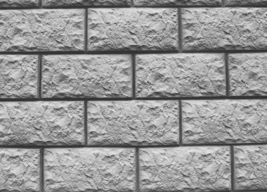 Duvar, yapay taşı taklit eden ön cephe malzemesi (dikdörtgen kiremitler) ile kaplıdır..